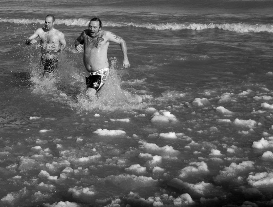 Chemistry teacher Marcel Grdinic (left) and friend of Grdinic Jamie Bradley run out of Lake Michigan at North Avenue Beach during the winter of 2010. Due to the ice in the water, their legs were left scratched and bleeding. Photo courtesy of Dawn Grdinic. 