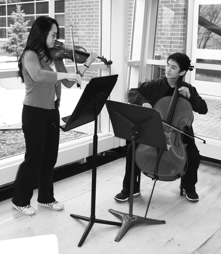 Junior Noelle Yoo (left) and Freshman Josiah Yoo (right) practice a duet together. They have won multiple awards from numerous competitions. Photo by Rachel Lee.