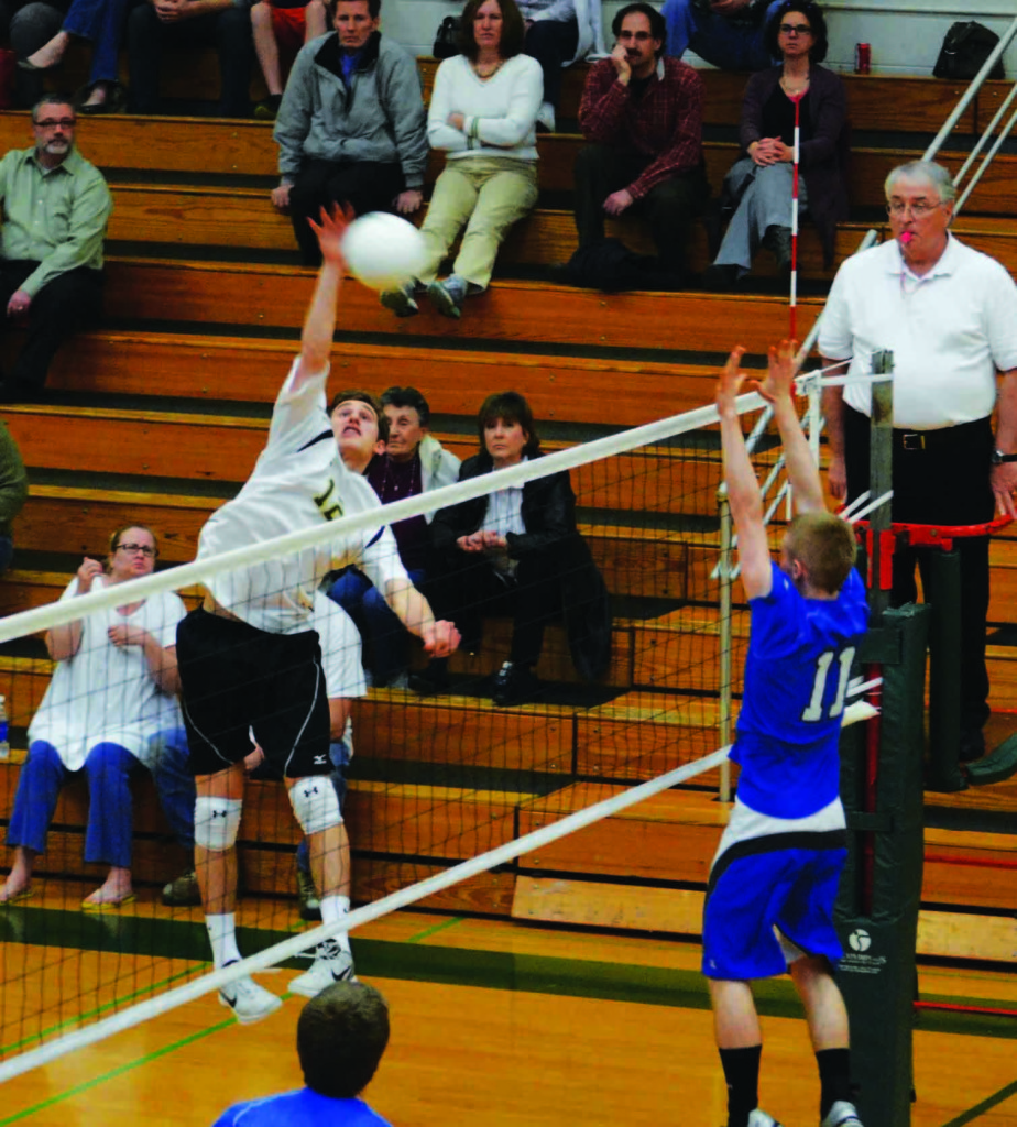 Outside hitter Joey Calvetti records a kill against Maine East during an April 8 home game. Over spring break, the team won its first ever Wheaton Warrenville South Tiger Classic championship.
