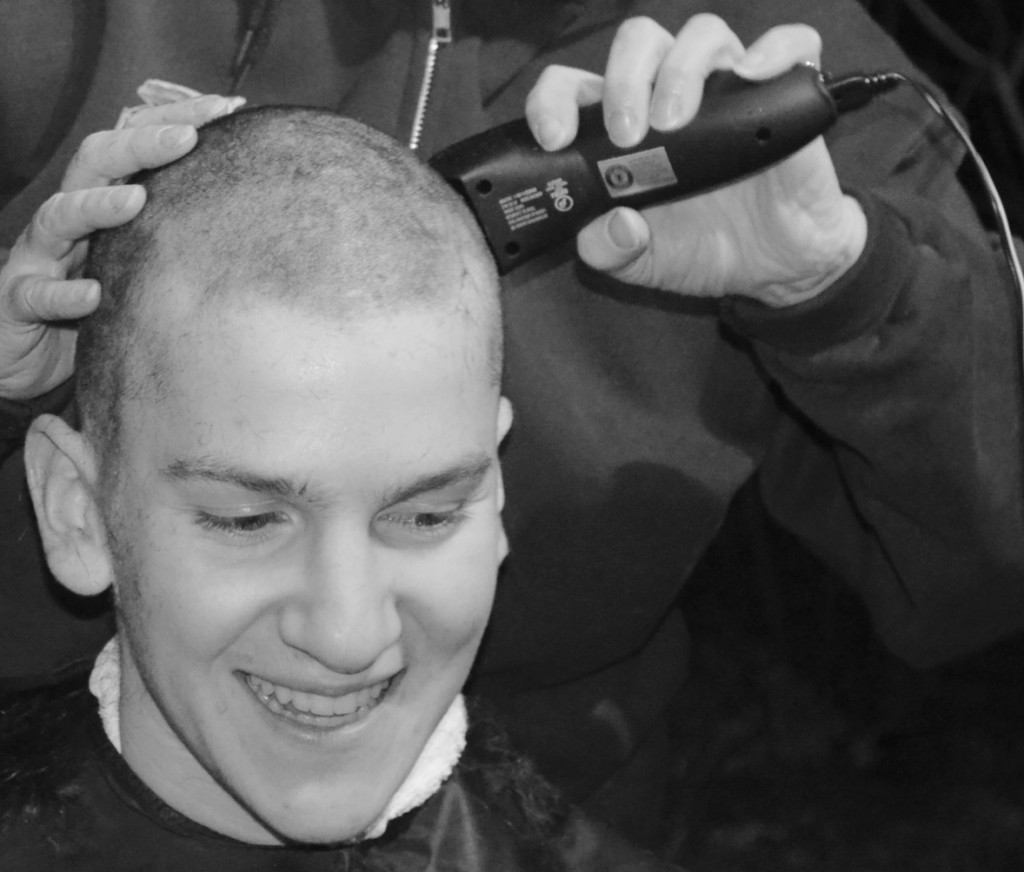 Junior Kevin Medansky’s mother shaves her son’s head in their driveway. Medansky continues to raise money for the St. Baldrick’s Foundation. Photo by Jessica Lee.