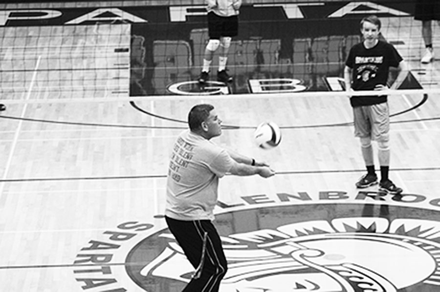 Chris Cooper, head boys volleyball coach, demonstrates proper passing form. Cooper has been coaching boys volleyball at Glenbrook North for over a decade. Photo by Morgan Berg