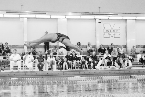Senior Kaya Nowak dives during a meet at Maine West on Oct. 16. She placed third in the diving portion of the meet. She also swam the 200m freestyle relay and the 200m medley relay. The team won the meet 123 to 62. Photo by Meghan Cruz. 