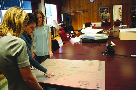 ACRON architect Erin Miller (left), Kris Frandson, associate principal for administrative services (second from left), and director of operations Kim Ptac review blueprints for the construction of the private changing stalls in the gym locker rooms. The stalls are scheduled to be constructed the summer of 2016. Photo by Emily Chwa