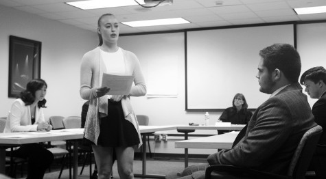 Sophomore Julia Laughlin (standing) takes on the role of a lead attorney and cross examines junior Brandon Friedman (right), acting as the witness, during the mock trials conducted by the business law class. Judge Jeanne Reynolds (center) presided at the mock trial held on April 22. Photo by Hailey Koretz