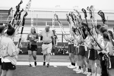 Senior Madison Fox walks with her father, surrounded by her teammates during Senior Night on April 18, 2016. GBN defeated Warren 19-3. Photo by Alec Mawrence. 