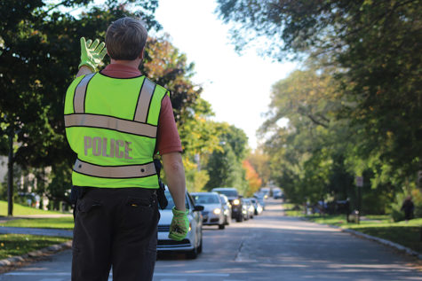 School resource officer John Seiler conducts traffic as a stream of drivers leave school via Second Street to Techny Road. The number of reported car accidents in the GBN parking lot has increased from previous years. Photo by Sydney Stumme-Berg.