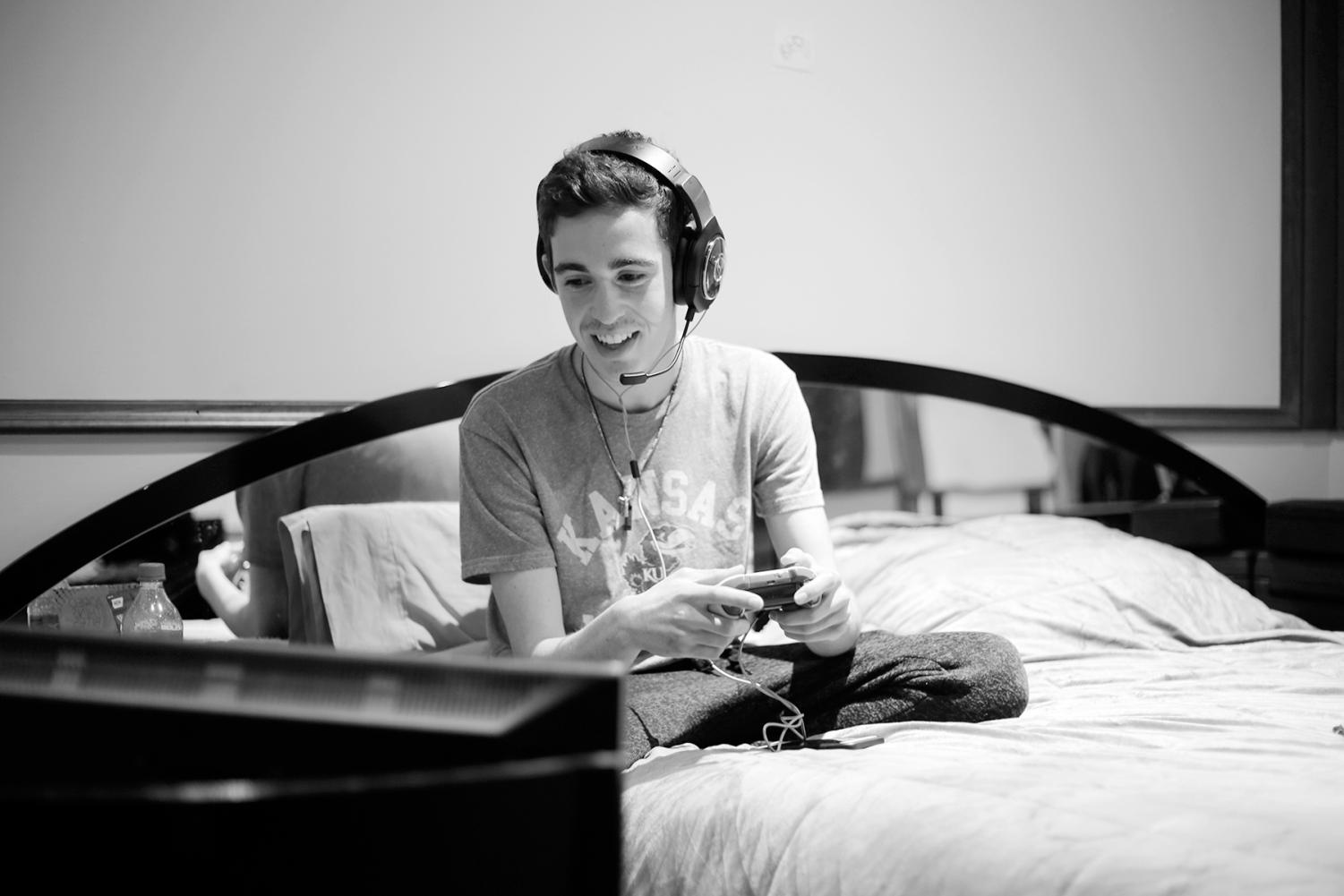Senior Mitchell Wilson plays Fortnite using a monitor he set up next to his bed. Wilson spends lots of time playing the game and said he has been called out of school to play. Photo by Chloe Carroll