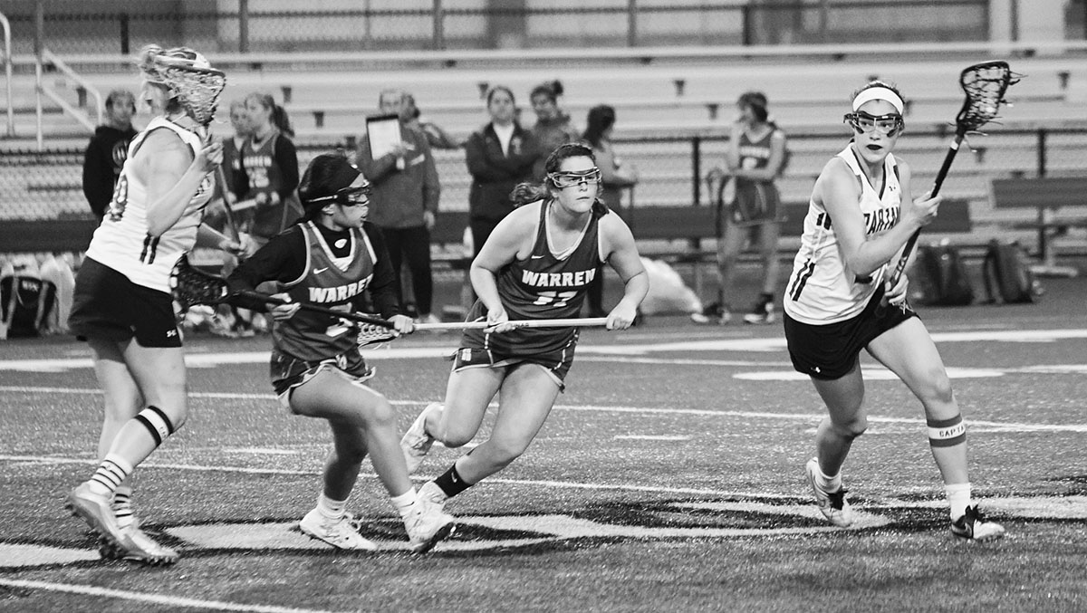Senior Naomi Lutz (right) plays offense in the girls lacrosse game against Warren Township on May 14. Next year, she plans to attend the Massachusetts Institute of Technology as a lacrosse commit. Photo by Richard Chu.