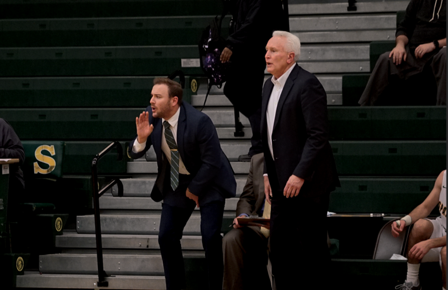 Tyler Kurz, assistant boys varsity basketball coach (left), directs the team alongside Dave Weber, boys basketball head coach, in a game against Prosser Career Academy on Nov. 19. This is Kurz’s second year as a member of the varsity staff. Photo by Richard Chu