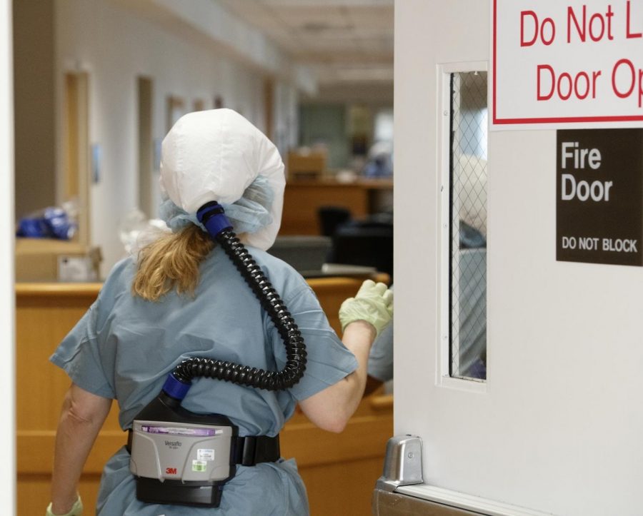 A Glenbrook Hospital COVID-19 clinical team member wears personal protective equipment including a powered, air-purifying respirator, also known as a PAPR. The clinical team member entered the nurses’ station where she was to be covered with a protective gown before caring for a patient.
Photo courtesy of Jon Hillenbrand, NorthShore University HealthSystem