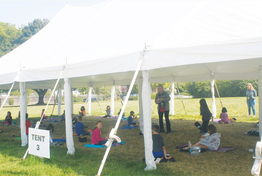 Students at Greenbriar Elementary School sit under one of the tents outside the school taking a mask break while eating lunch. Students were given the choice between learning remotely or in person. Photo by Ellie White