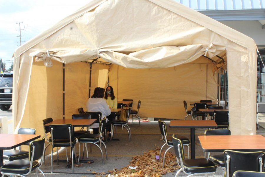 Two+customers+dine+in+a+tent+in+the+parking+lot+outside+Once+Upon+a+Grill.+Once+Upon+a+Grill+installed+a+tent+to+continue+providing+a+dine-in+option+for+costumers+while+the+weather+gets+colder.+Photo+by+Brooke+Falk