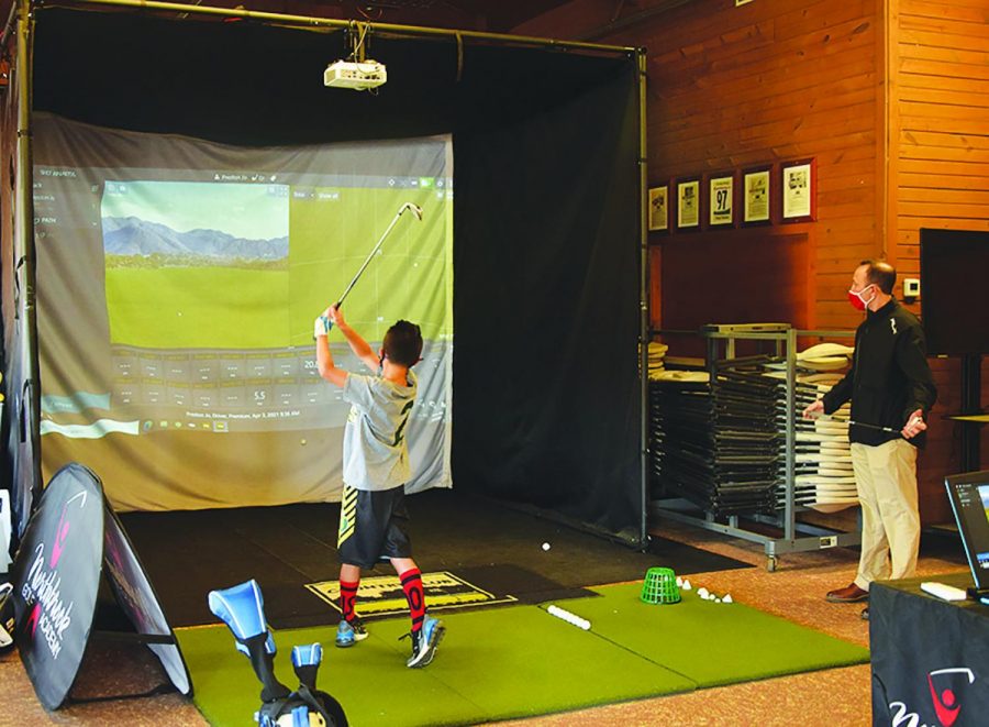 During a private lesson on April 3, Michael Wenzel, director of instruction at Northbrook Golf Academy, observes a player using a TrackMan Golf Simulator at the Chalet at Meadowhill Park. The simulator will be moved to Heritage Oaks once the renovations are complete. Photo by Natalie Sandlow