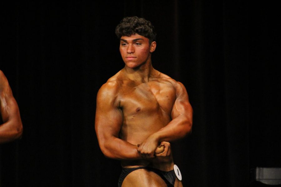 After an announcer calls his number, senior Matt Karis flexes one of the mandatory poses during his first bodybuilding competition. Karis placed fourth in the teen division, competing at Jefferson High School in Rockford on Oct. 9. Photo by Drew Mutchnik