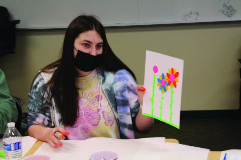 During a Mindfulness Club meeting held on May 4, senior Lauren Brodsky shows her painting of flowers. Among other mindfulness activities, the club also makes snacks and practices mindful eating. Photo by Noah Kaufman