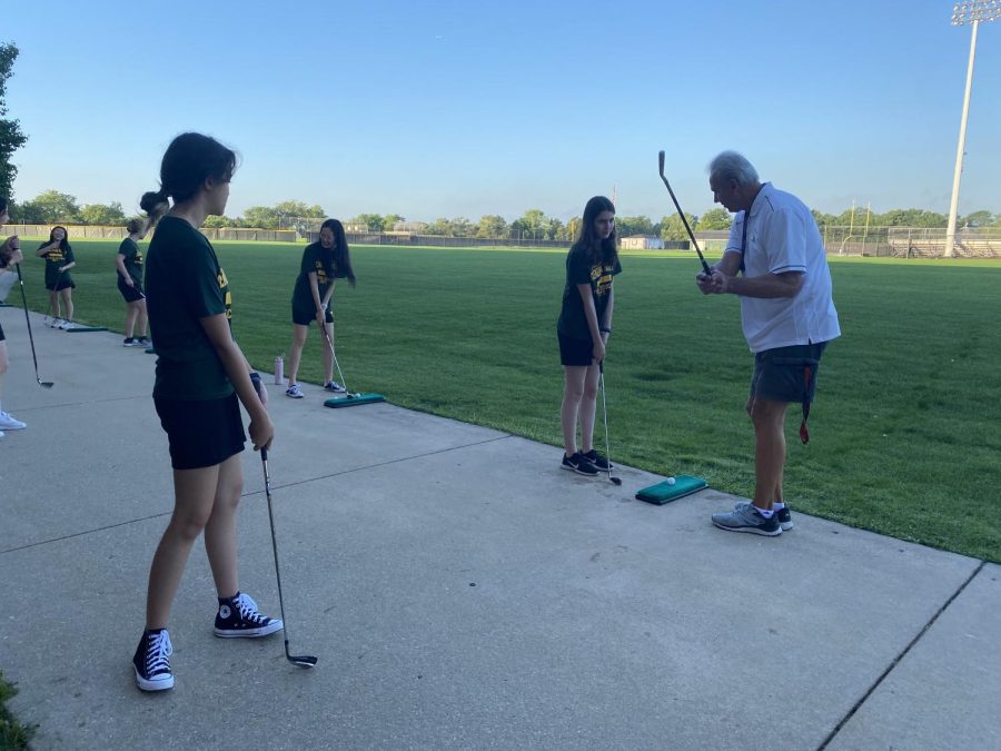 In the golf unit, P.E. teacher Michael English (right) assists early bird P.E. students with their swings. Students can now make up a regular class in one early bird P.E. class, whereas two early bird P.E. classes were needed for a class makeup before this year.