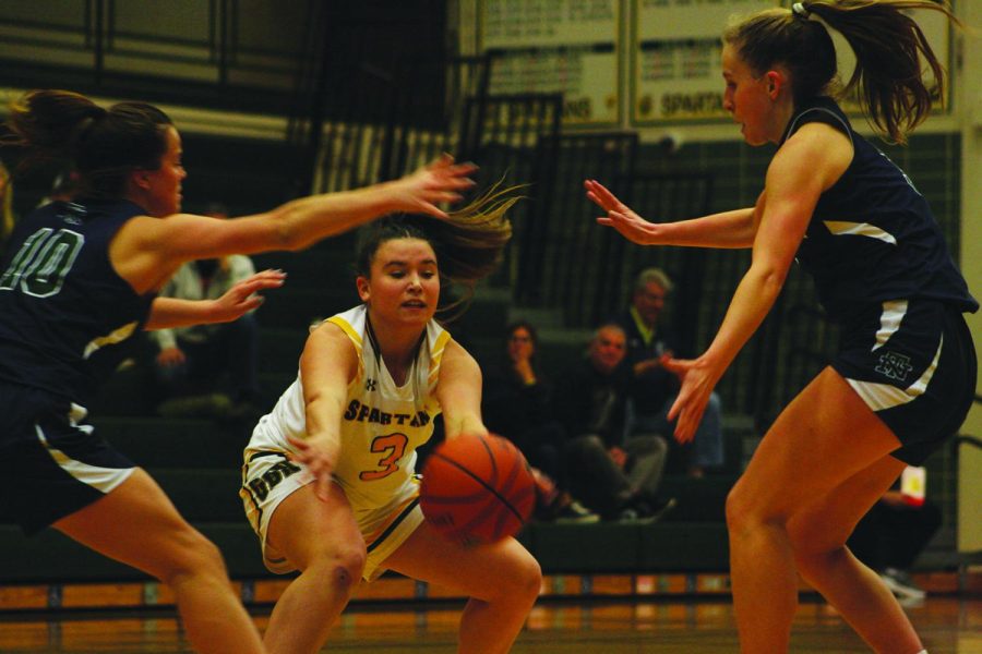 Junior Grace Gertner (middle) passes during a game against New Trier on Dec. 6. Glenbrook North won 54-40 and as of Dec. 8, the team has an overall record of 7-1 and 2-1 in conference. Photo by Jada Glazebrook.