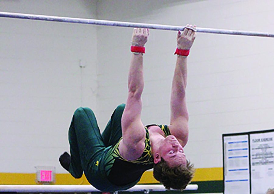 Senior Michael Glowacki performs a high bar routine at a home meet on March 22. The IHSA is scheduled to host the state finals this year on May 12 and May 13. Photo by Jada Glazebrook