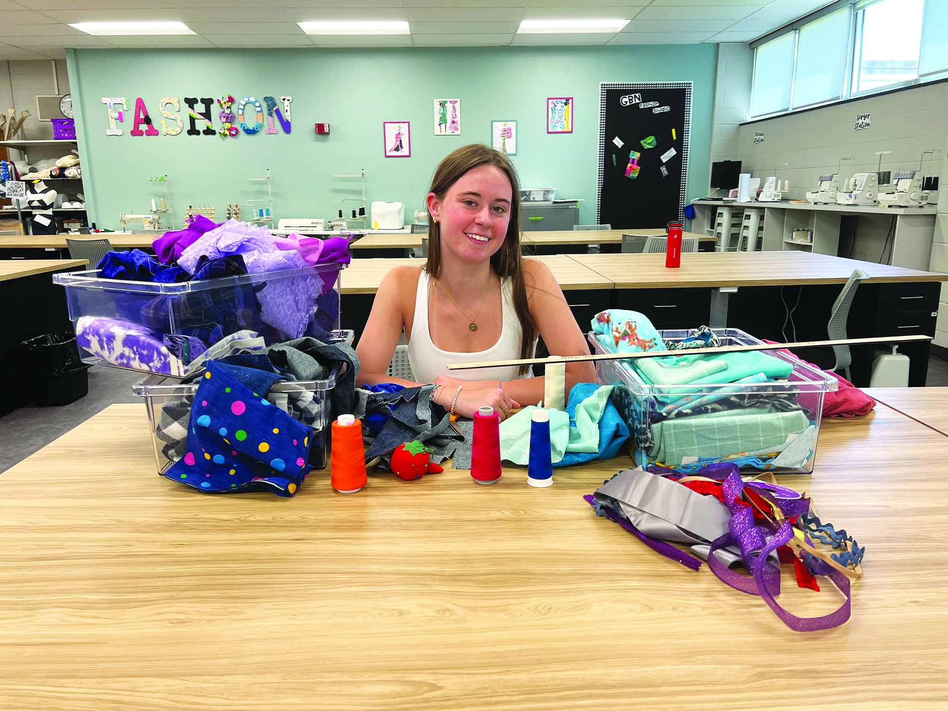 Senior Darcy Brudenell sits with fabric, thread and other materials she uses while sewing. Most recently, Brudenell has used the embroidery machine in Glenbrook North’s fashion studio to make custom college merchandise for her peers.