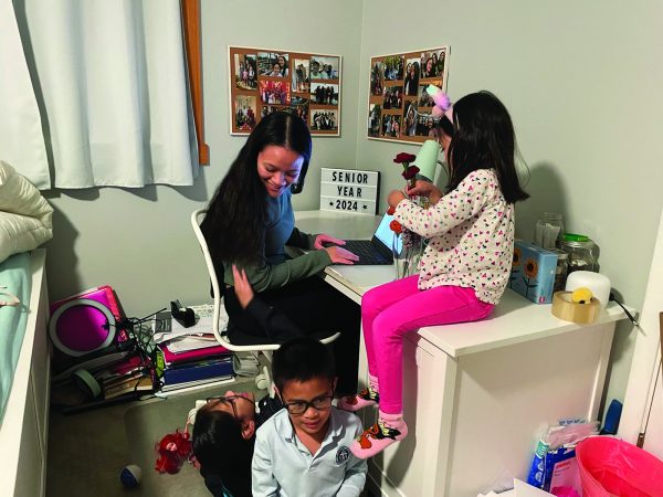 Torch editor Marissa Fernandez attempts to do homework while her siblings distract her. Even though moments like these may seem like a nuisance, they can create the best memories. Photo by Avery Copeland