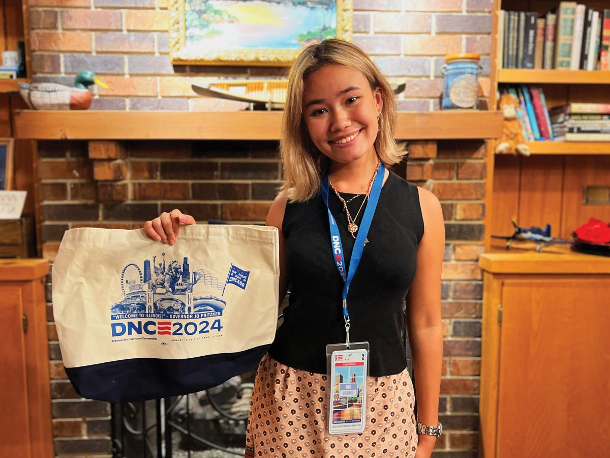 Alumna Claire Satkiewicz (‘23) holds up a souvenir from the Democratic National Convention. During the convention, speakers like U.S. Senator Cory Booker and presenters from other countries presented to the Illinois delegation each day at breakfast.