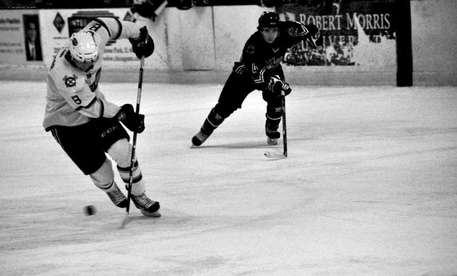 Senior Joseph Widmar, a center for the Chicago Steel, steers the puck away from an opposing Lincoln Stars player in a Nov. 23 game. The Steel won the game by a score of 4-2 and hold an 11-6-2 record as of Dec. 3, while maintaining 4th place in the Eastern Conference of the USHL. Photo by Zach Zilber. 