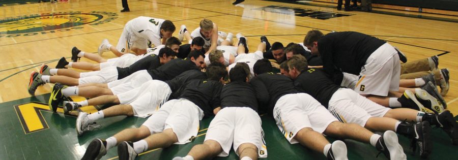 As a pregame routine, the boys basketball team huddles in preparation for its season opener against Niles West, a 67-64 win on Nov. 20 in which senior Kellen Witherell scored 16 points. Photo by Hope Mailing