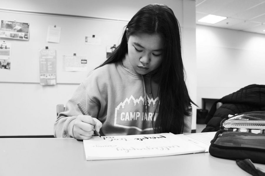 Junior Cameron Fong concentrates as she practices writing calligraphy. Fong uses calligraphy to create  cards and vinyl stickers. She also has an Instagram account where she features her work.