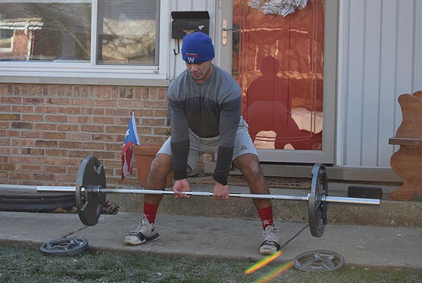 Senior Drake Marquez lifts weights outside of his house on the morning of Saturday, Dec. 5. Due to his right leg injury, Marquez needed plates in his leg and was disqualified from his Marines program. Photo by Natalie Sandlow