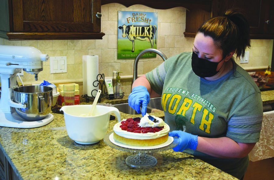 Laura Ruesch, executive assistant in the Deans’ Office, frosts a white cake using whipped cream frosting for an order. Ruesch began running her baking business from her kitchen in 2014. Photo by Natalie Sandlow