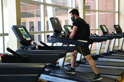 While wearing a 40-lb vest, P.E. teacher Justin Weiner trains in the fitness center on March 19 for his Mount Kilimanjaro climb. Photo by Alex Garibashvily