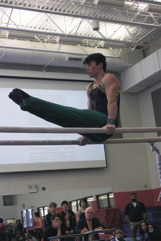 On the parallel bars, junior Kian Sullivan competes in a meet at Niles West on March 12. Sullivan scored an 8.8, placing third.