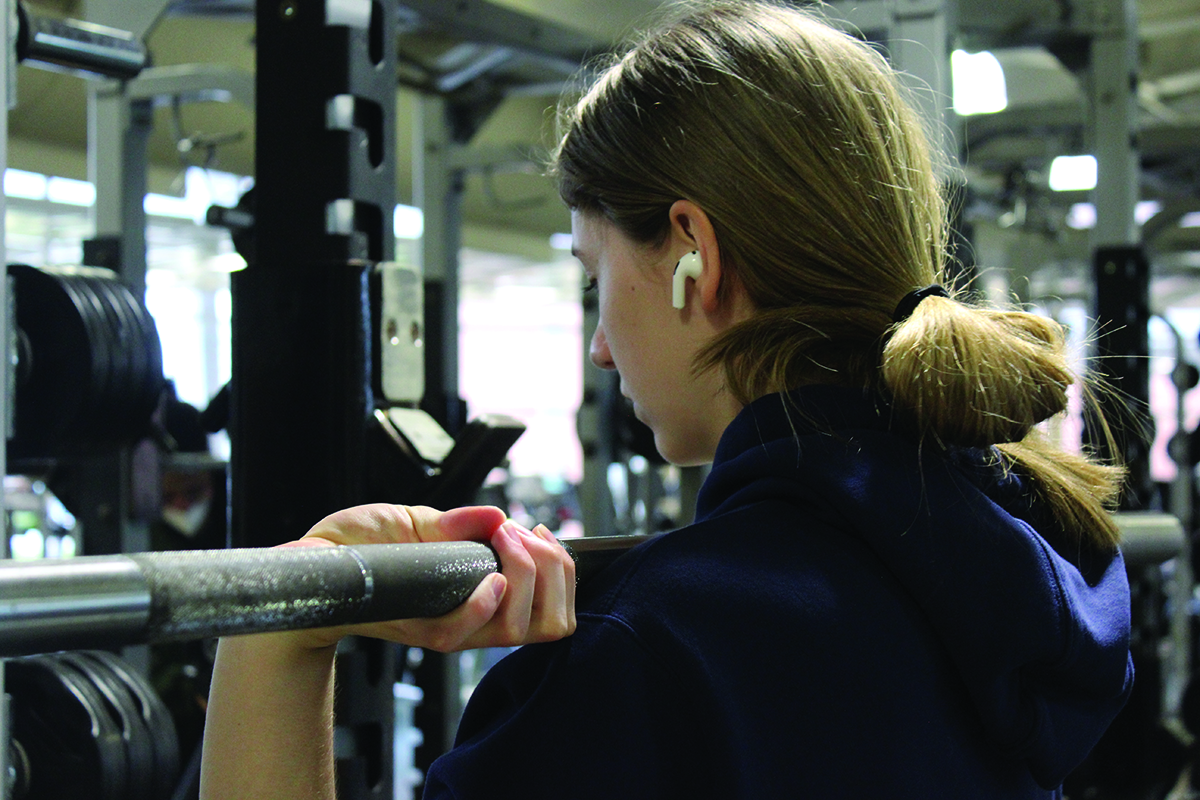 Sophomore Brianna Owen listens to music while working out in the fitness center. Listening to music while exercising can increase motivation and strengthen the ability to learn motor skills. Photo by Jenna Amusin.