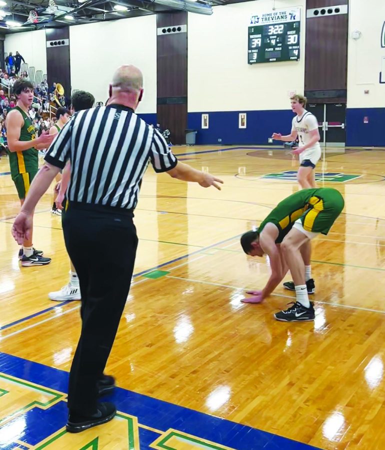 An IHSA referee calls a foul against Glenbrook North with three minutes left during a varsity boys basketball game on Feb. 10. Verbal abuse from fans and coaches has led to the resignation of some IHSA officials. Photo by Kate Leverenz
