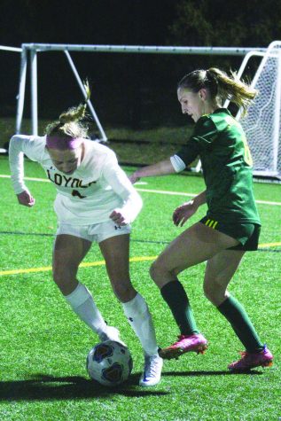 Junior Ella Panek (right) attempts to steal the ball during a game against Loyola on March 16. Turf can cause cleats to get stuck, increasing the risk of injury to athletes compared to natural grass. Photo by Jiya Sheth