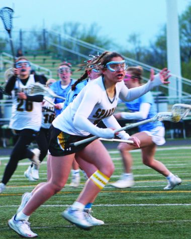 Junior Rachael Rizzi runs with the ball while protecting her stick in a game against DePaul College Prep on April 24. The Spartans lost the game 8-7. Photo by Chase Goldstein
