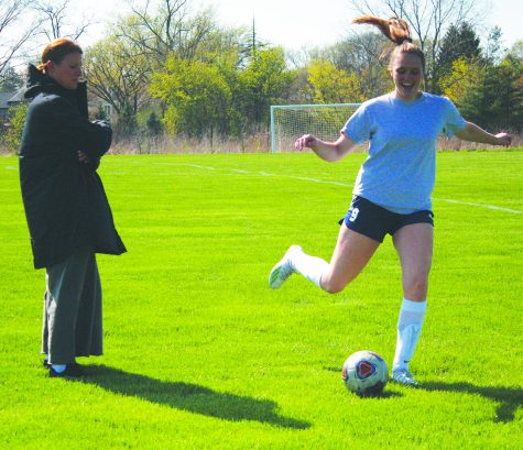 Senior Kate Leverenz warms up as Meghan Bargar, assistant girls soccer coach, observes Leverenz. Female athletes can see women as role models in sports by having female coaches. Photo by Jada Glazebrook 
