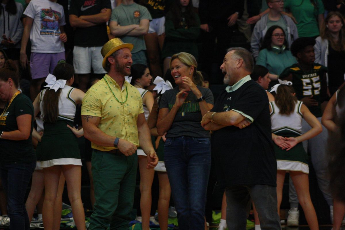 Principal liaison Ryan Bretag (left) and interim principals Marina Scott (center) and Stephan Bild watch students perform school spirit cheers at the Loyalty Day assembly on Sept. 1. Bretag, Scott and Bild were hired after former principal Jason Markey resigned at the end of last school year. Photo by Emma Hirsch