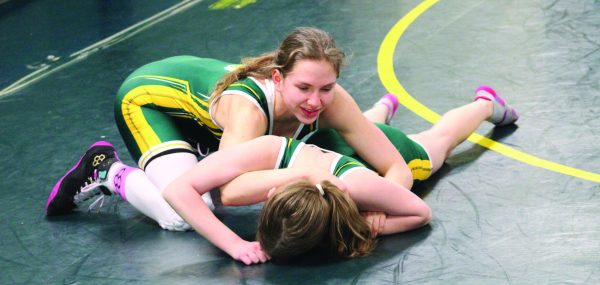 Freshman Ariella Dobin uses the half nelson move on her teammate, sophomore Zoe Handler. The girls wrestle with boys in practice, but this is the first year the girls have competed in all-girls tournaments. 
