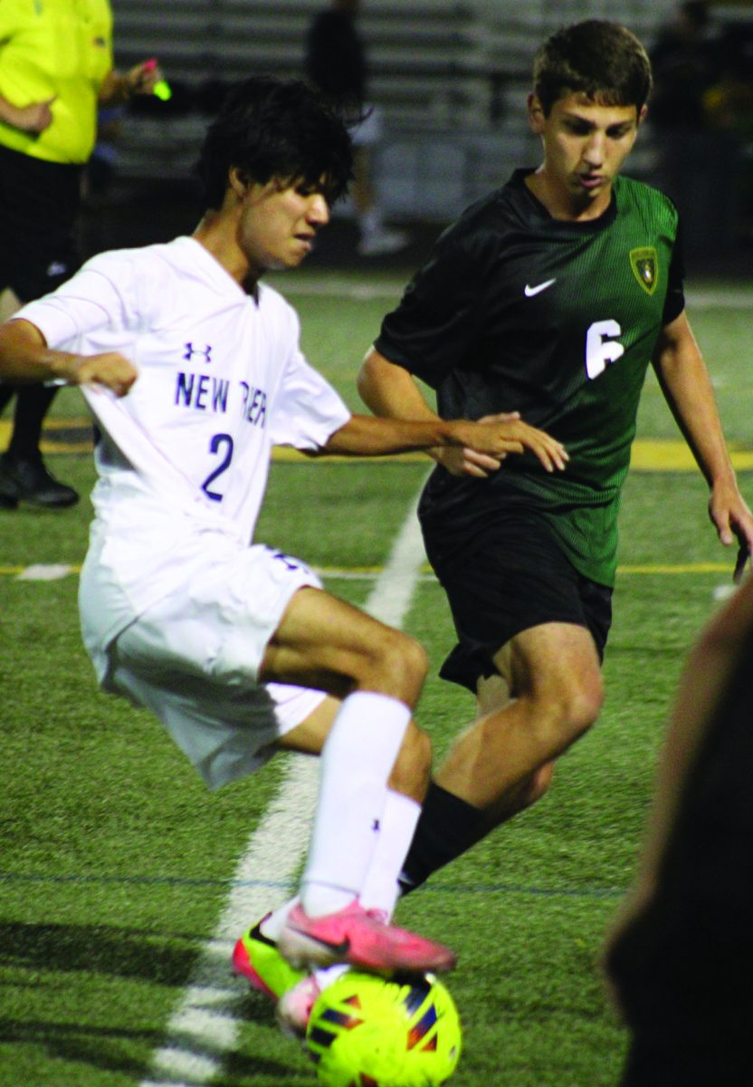 Senior Giorgi Kipiani defends a New Trier opponent in a game on Sept. 19. The team lost the game 3-0, falling to 1-2-1 Central Suburban League South Division. Photo by Lara White