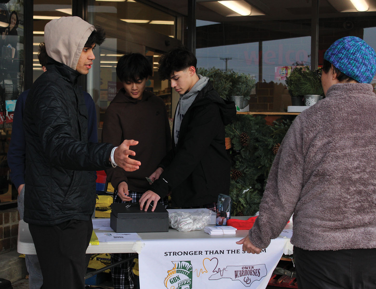 Neel Gandhi, Student Association Executive Board President (left), talks with a Jewel-Osco customer about donating to Charles D. Owen High School. The Student Association raised over $4,000 from customers shopping at Jewel-Osco and Sunset Foods. 