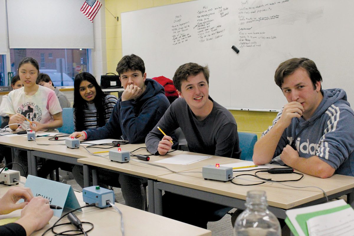 Seniors Atchaya Muthupalaniappan (left), Martín Sarmiento (center) and junior Jonathan Byrne listen to a question during a Scholastic Bowl match against Vernon Hills on Jan. 30. The team won by 30 points to bring their season record to 7-2.