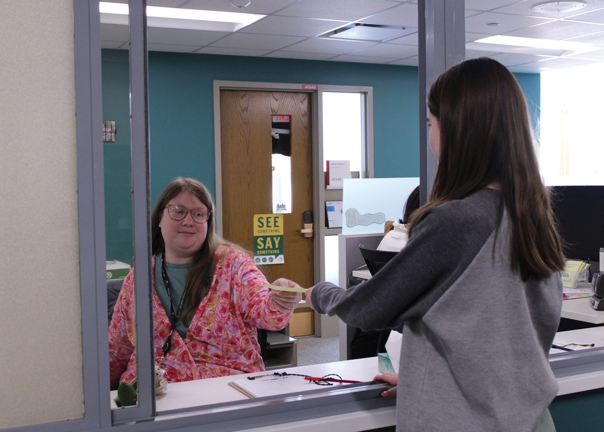 Attendance clerk Brittany Paul distributes attendance slips throughout the school day. The district is working on revising its current attendance policy with the goal of helping increase attendance rates. 
