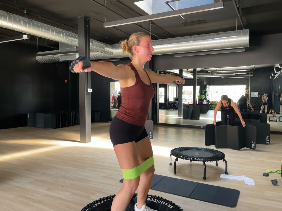 During the bounce portion of her workout, Torch editor Ellie Edsey does jumping jacks while holding ankle weights. Bounce and sculpt combines a cardio workout on a mini-trampoline with strength training. 