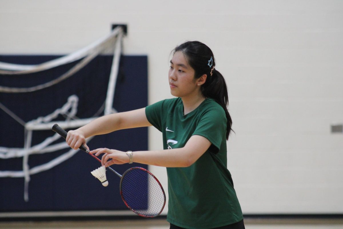 Senior Juliette Zhou serves during a conference game against New Trier on April 23. The team won its fifth consecutive conference title this season.