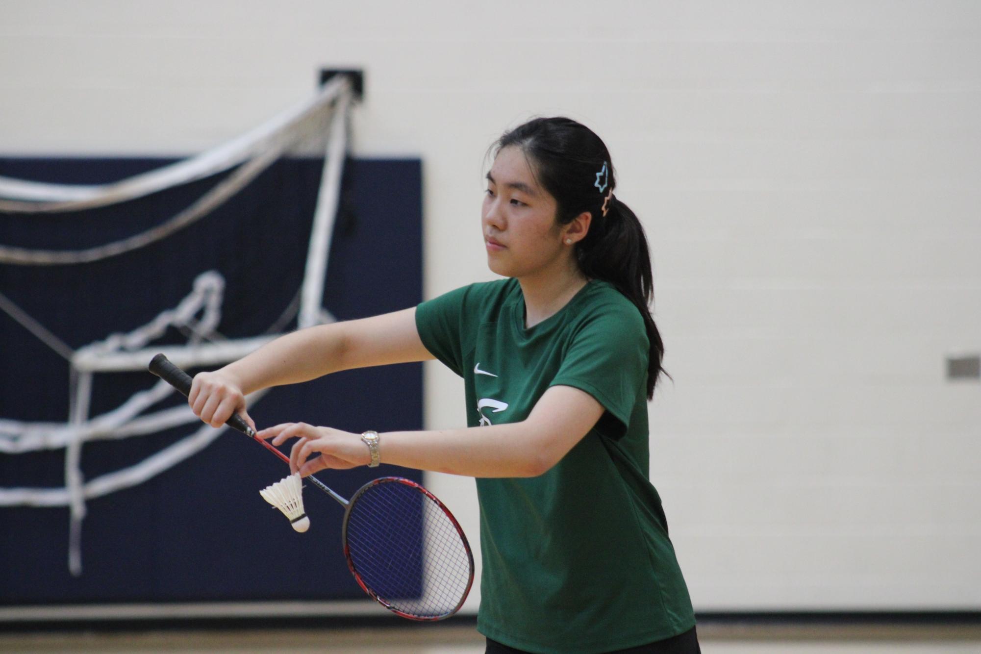 Senior Juliette Zhou serves during a conference game against New Trier on April 23. The team won its fifth consecutive conference title this season.